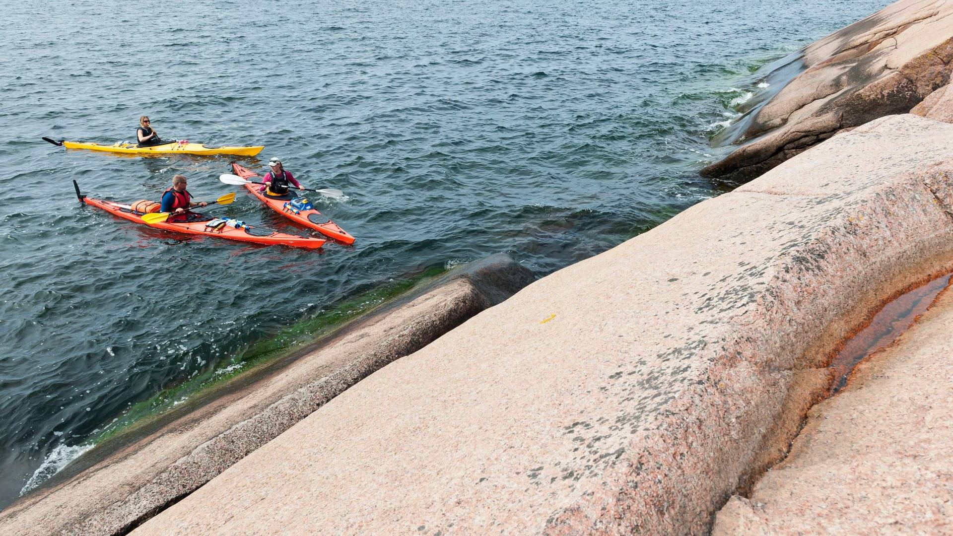 Paddlare på havet vid en klipphäll, Blå Jungfruns nationalpark, Kalmarsund.