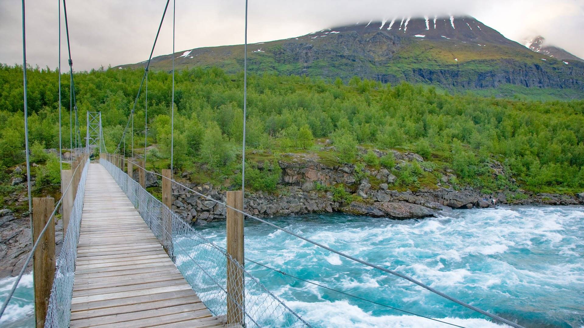Hängbro över älven Vuojatädnoen längs Padjelantaleden i närheten av Akkastugorna i Stora Sjöfallets nationalpark.